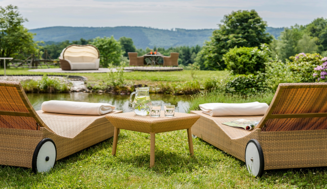 2 Sonnenliegen stehen vor der Teichanlage