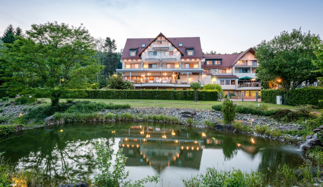 Blick von der Teichanlage auf den Heimathenhof bei Abenddämmerung