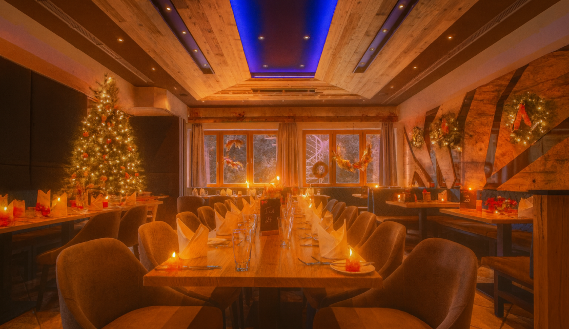 Festlich gedeckter Tisch mit Weihnachtsbaum im Hintergrund im Landhotel Heimathenhof