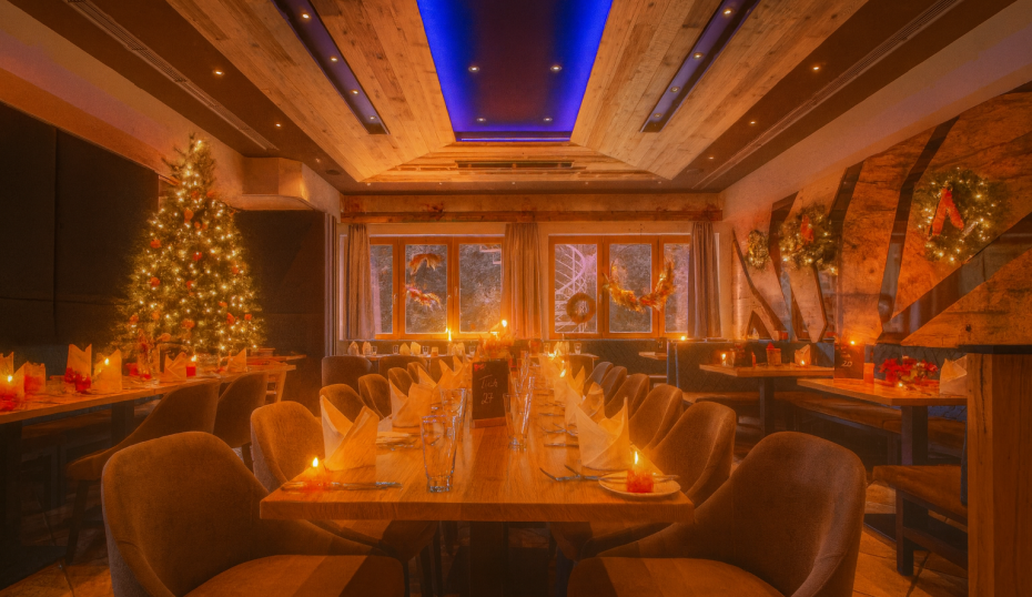Festlich gedeckter Tisch mit Weihnachtsbaum im Hintergrund im Landhotel Heimathenhof