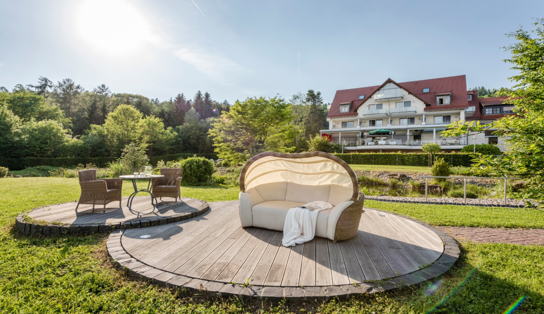 Lounge am Teich im Hintergrund das Hotel