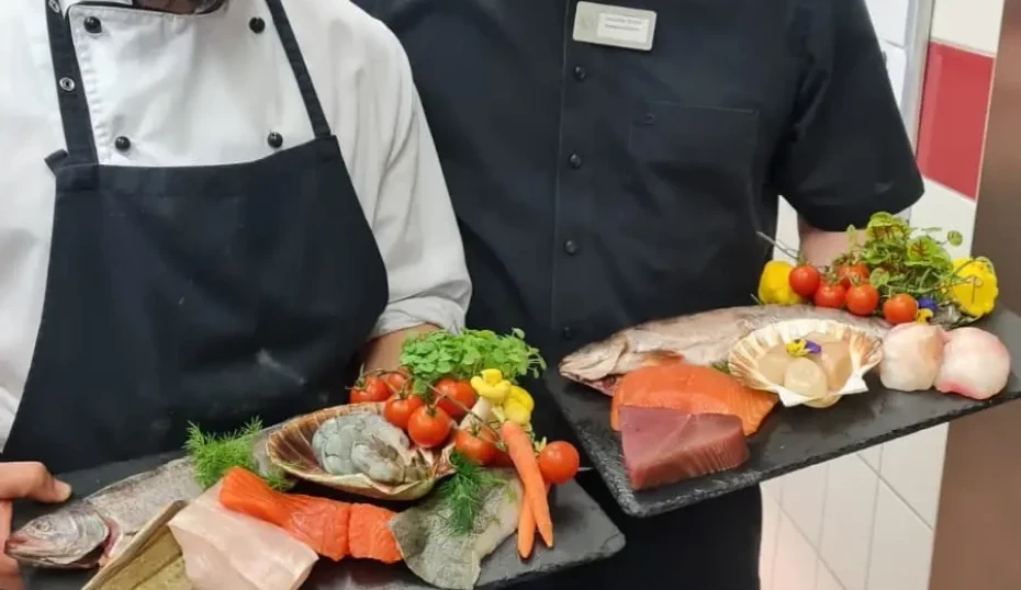 Unsere Mitarbeiter mit einer Platte in Hand mit einer Fischauswahl